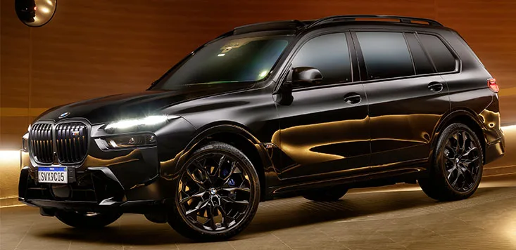 BMW X7 M60i preto em estúdio, vista lateral tríquartos